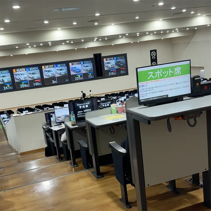 Live bidding screens inside a Japanese vehicle auction hall
